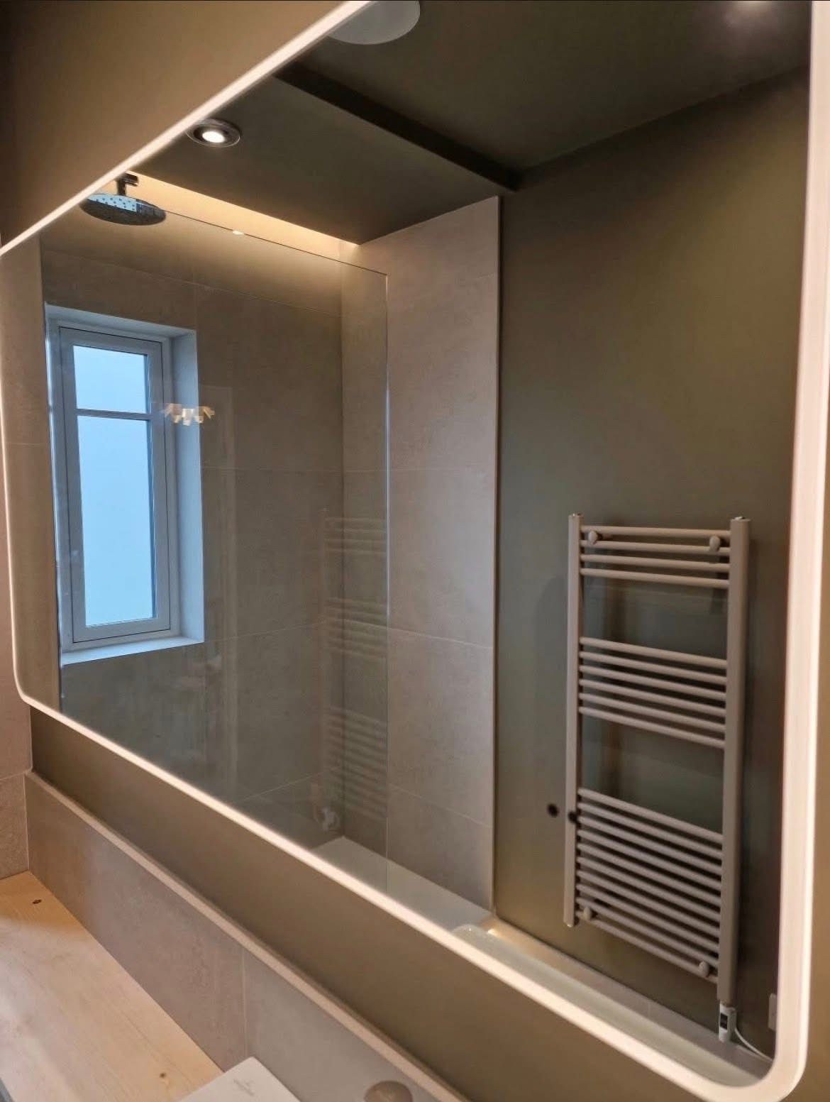 Bathroom mirror and towel rail with ceiling downlights